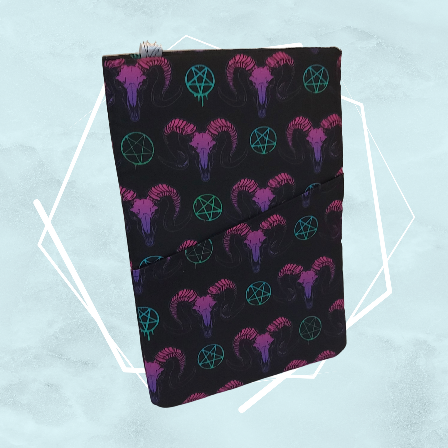 A gothic black booksleeve with a pattern of goat heads and occult symbols in purple, green and pink colors, made for readers to keep books safe