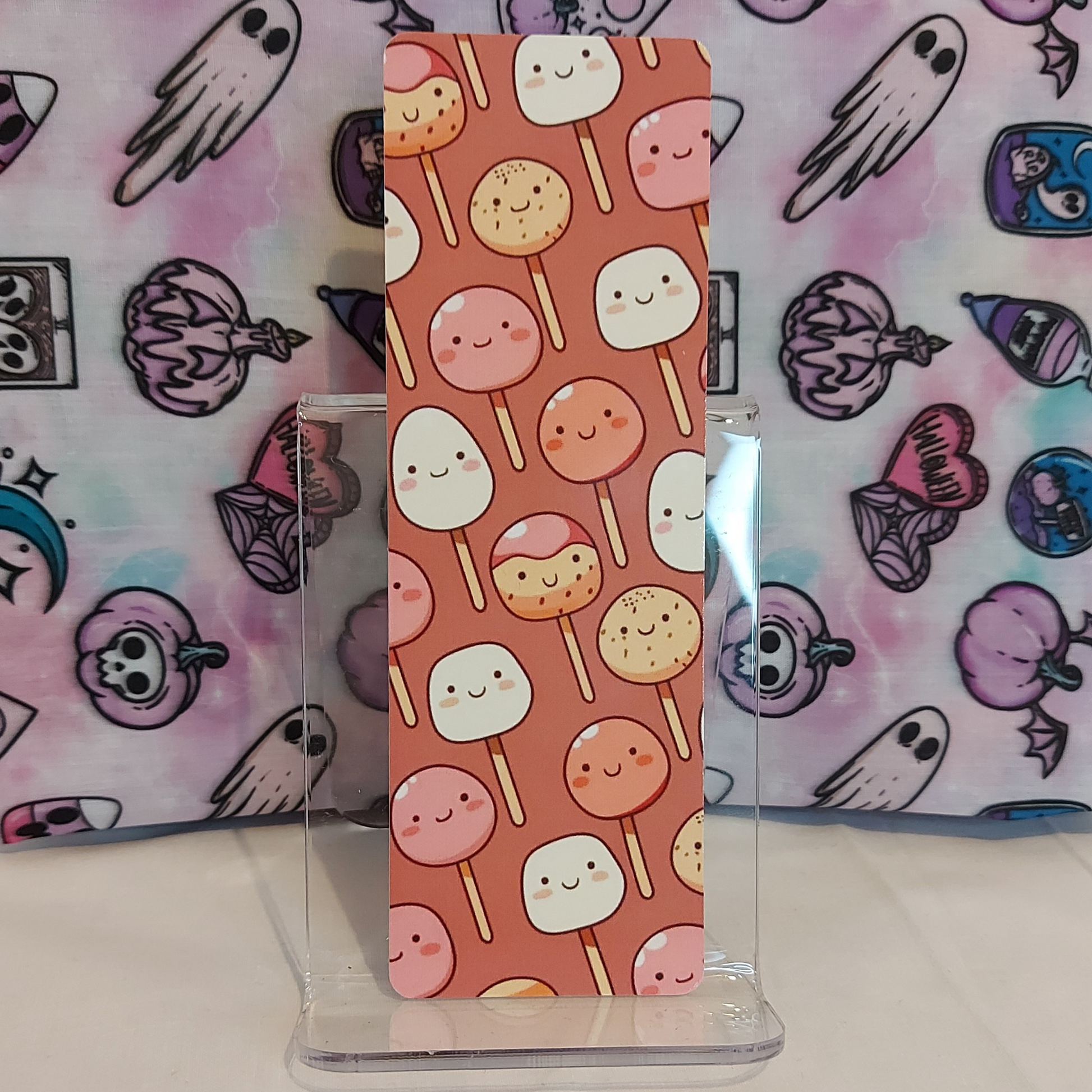 Mauve colored bookmark featuring japanese snacks and sweets, made for readers, by a UK-based female indie artist