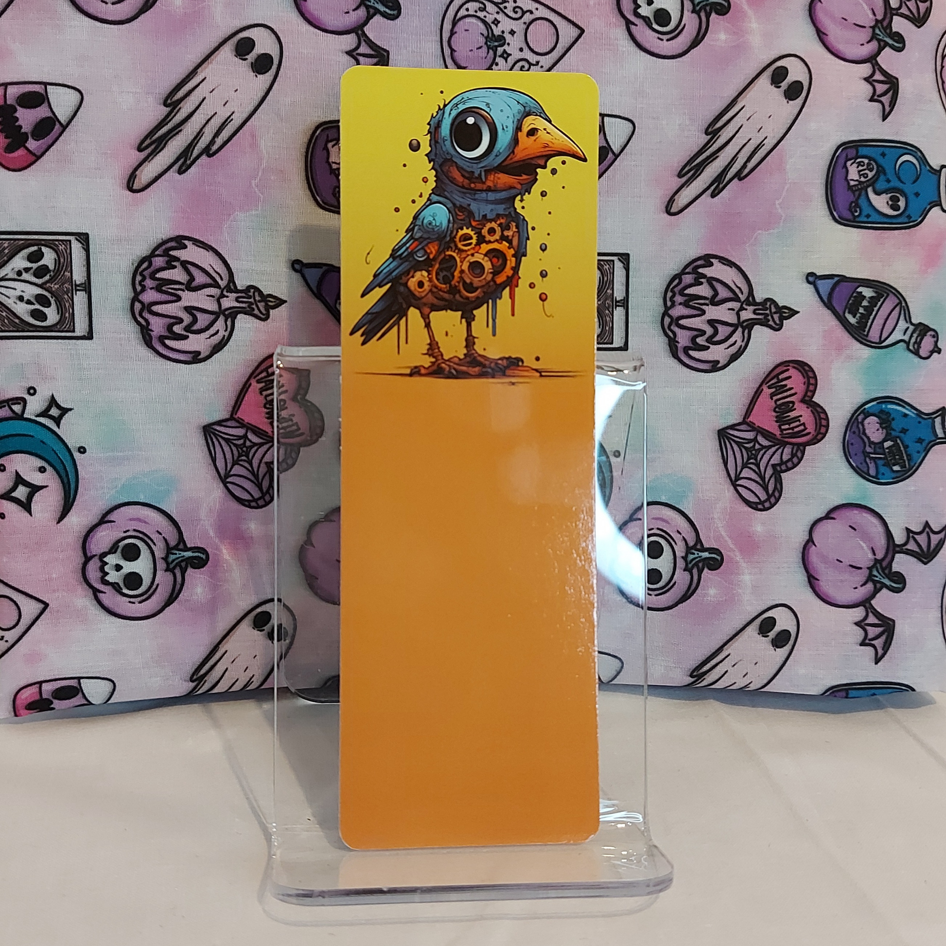 A freaky and unique bookmark with a colorful illustration of a steampunk bird character, made in the UK by indie artist Freya's Madpeak