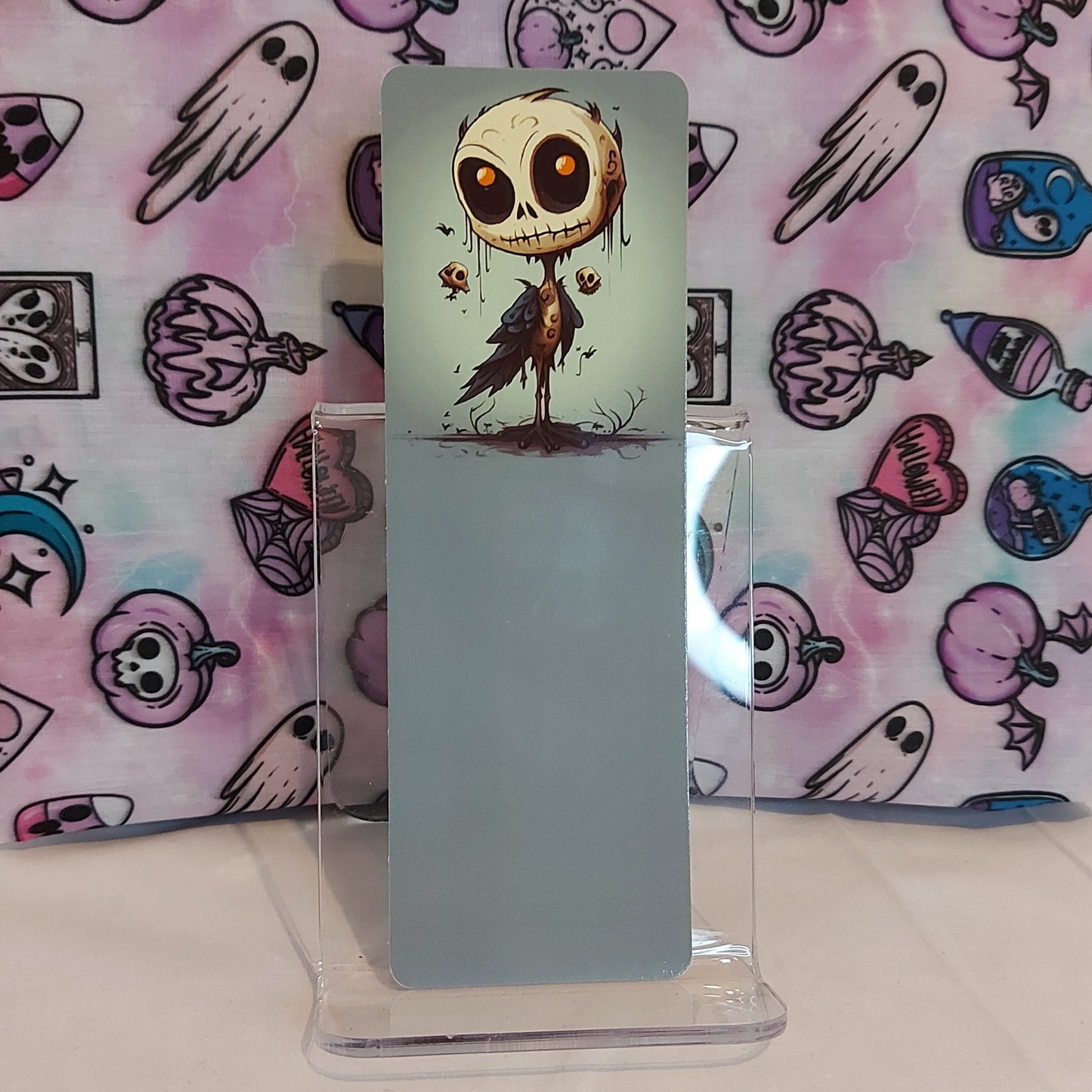 A freaky, quirky bookmark featuring a gothic style illustration of a skull on a bird, made for readers and book lovers as an accessory