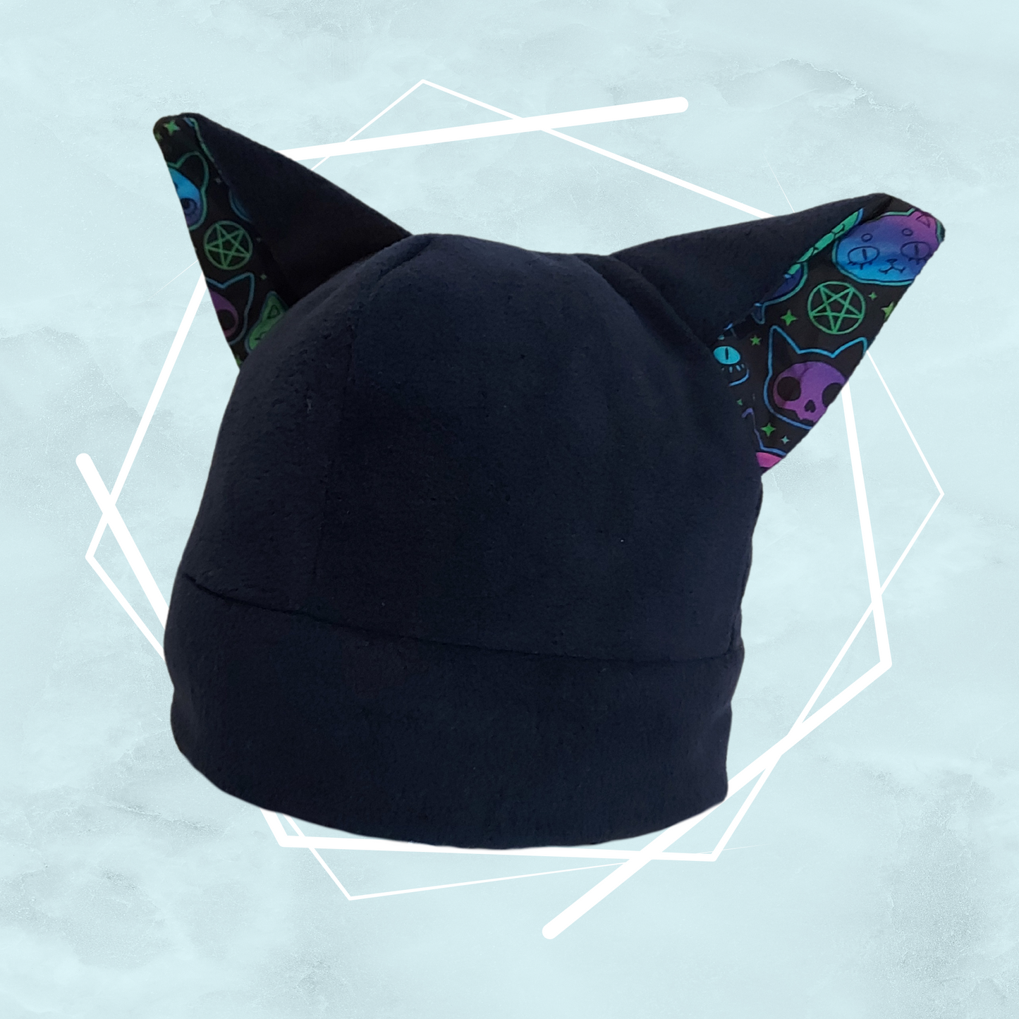 Dark navy blue colored handmade beanie hat with cat ears and witchy themed colorful patterned cotton fabric on inner ears, in whimsycal style