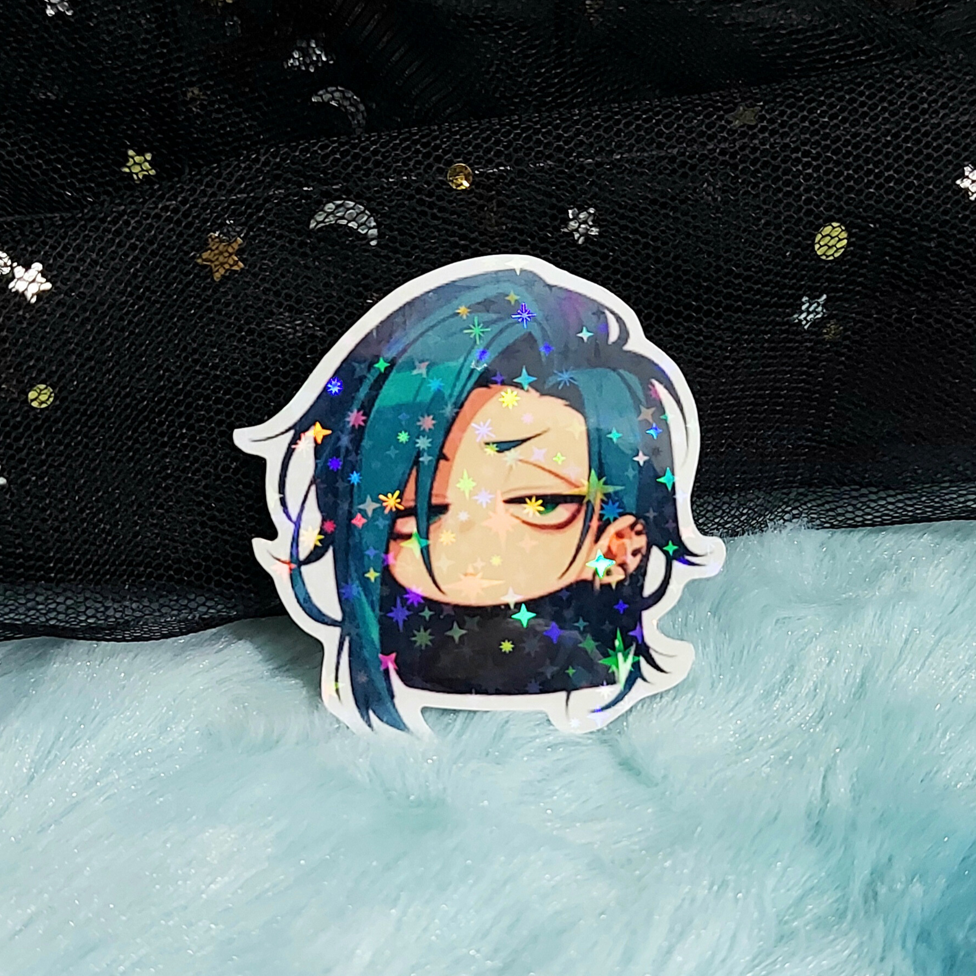 Holographic sticker of an anime character with blue hair on a textured surface.