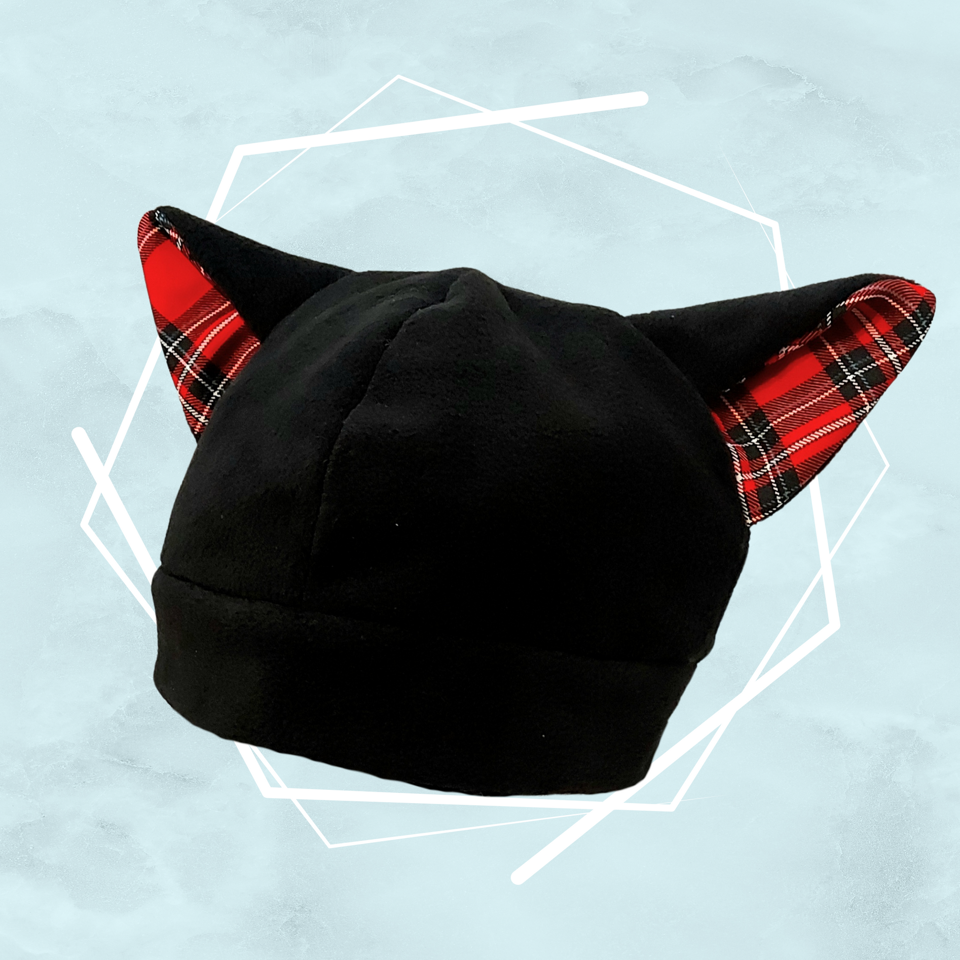 Black colored warm fleece beanie with cat ears and red pattern on it, made for winter by UK-based indie artist